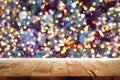 Wood table top with bokeh from decorative light on Christmas tree in background Royalty Free Stock Photo