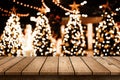 Wood table top with christmas tree and blur light bokeh background Royalty Free Stock Photo