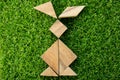 Wood tangram puzzle in rabbit shape on artificial green grass Royalty Free Stock Photo