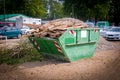 wood waste is collected on a construction site in a green waste container Royalty Free Stock Photo