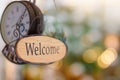 Wood welcome sign hanging with wall clock. selective focus