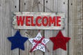 Wood welcome sign with red, white and blue stars