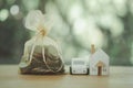 Wood whit car, wood white house, and a golden bag of stack of coins with money bag on wood table Royalty Free Stock Photo