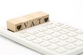 Wood word VAT and Wood Heart placed on a white calculator as background finance concept and business concept