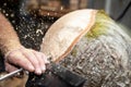 Wood working man cuts rotating piecee of timber