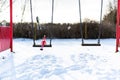 Woodbridge Suffolk UK February 11 2021: A naughty Christmas elf playing on a kids swing set in a public park.Naughty, christmas, Royalty Free Stock Photo