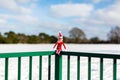 Woodbridge Suffolk UK February 11 2021: A naughty Christmas elf sitting outside in the snowy winter landscape enjoying the winter