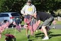 Volunteers placing an American Flag on the grave of a Military Veteran for Memorial Day