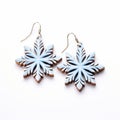 Woodcarved Blue Snowflake Earrings On White Surface