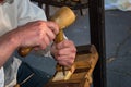 Woodcarver dressed in folk costume carves from wood Royalty Free Stock Photo