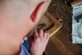 A woodcarver processes a walnut wood board with a chisel. artisan makes a tea tray. vagatabon. tea tray.woodcarver art