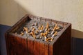 Woodden ashtray with sand full of smoked cigarettes Royalty Free Stock Photo