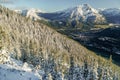 Wooded snow covered slope and mountains and valley in the distance Royalty Free Stock Photo