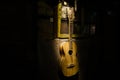 An wooden acoustic guitar is against a grunge textured wall. The room is dark with a spotlight for your copyspace Royalty Free Stock Photo