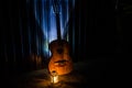 An wooden acoustic guitar is against a grunge textured wall. The room is dark with a spotlight for your copyspace Royalty Free Stock Photo