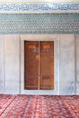 Wooden aged engraved door, marble wall and ceramic tiles with floral blue decorative patterns, Sultan Ahmet Mosque, Istanbul Royalty Free Stock Photo