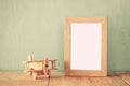 Wooden airplane toy over wood table next to blank photo frame. retro filtered image Royalty Free Stock Photo