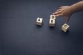 Wooden alphabet cube with words ABCD closeup and children hands on black background