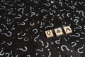 Wooden alphabet tiles with Q&A letter on black paper with QUESTION MARK