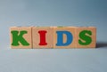 Wooden alphabet toy blocks with the text: Kids.  kids ABC cubes on blue background Royalty Free Stock Photo