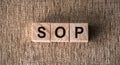 Wooden alphabets blocks building the word SOP - Standard Operating Procedure acronym
