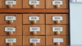 Wooden analog file cabinet drawers with years listed. Repository of information. University history room, maternity ward or