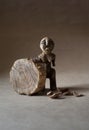 Wooden ancient statuette symbolizing woman with a piece of wood Royalty Free Stock Photo