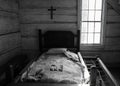 Wooden antique rope bed from 1800s with a cross on the wall from a historic farmhouse in Georgia