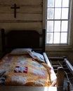 Wooden antique rope bed from 1800s with a cross on the wall from a historic farmhouse in Georgia