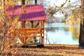 Wooden Arbor With A Table And Picnic Benches In The Open Air On The Background Of Fallen Leaves Near A Forest Lake