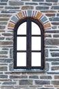 Wooden arched window in a stone wall