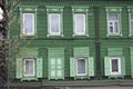 Wooden architecture of Siberia, old Windows with wooden carved architraves. old peeling paint on the wooden Windows Royalty Free Stock Photo