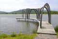 Wooden arcuate pier on the pond without people. Summer fresh morning