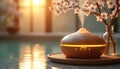 Wooden aromatherapy diffuser emitting steam. Warm light illuminates the device and blurred background. Cherry blossom branch in Royalty Free Stock Photo