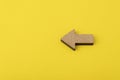 Wooden arrow on yellow background. Direction indicator. Copy space. Mockup Royalty Free Stock Photo