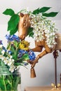 Wooden articulated dummy horse mannequin in white inflorescences with a small bouquet Royalty Free Stock Photo