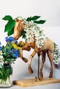 Wooden articulated dummy horse mannequin in white inflorescences with a small bouquet Royalty Free Stock Photo