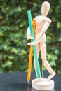 Wooden artist manikin standing with colour pencil Royalty Free Stock Photo