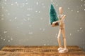 Wooden artistic figure holding christmas tree. Christmas holiday concept