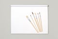 Wooden artistic paintbrushes on a white paper block