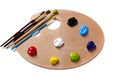 A wooden artists palette with bright colored paint and brushes Royalty Free Stock Photo