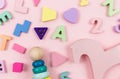 Wooden baby toys on a pastel pink background. Horse, numbers, blocks, puzzle shapes, pyramid, Royalty Free Stock Photo