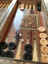 Wooden backgammon board game of pearl inlaid on brown background.