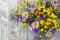 Wooden background with a bouquet of small wild flowers daisies, bells . Royalty Free Stock Photo