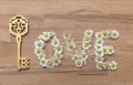 On wooden background from chamomile flowers word love is laid out Royalty Free Stock Photo
