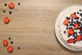 wooden background with cheesecake with strawberries and blueberries