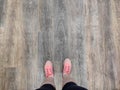 Wooden background and foots. Pink shoes on old wooden texture.