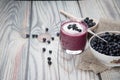 On a wooden background is a glass with a diet drink blueberry smoothie with whipped cream and a plate of blueberries on a napkin, Royalty Free Stock Photo