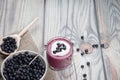 On a wooden background is a glass with a diet drink blueberry smoothie with whipped cream and a plate of blueberries on a napkin, Royalty Free Stock Photo