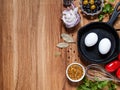 Chicken eggs in a cast-iron pan, olives, onions, mustard seed, t Royalty Free Stock Photo